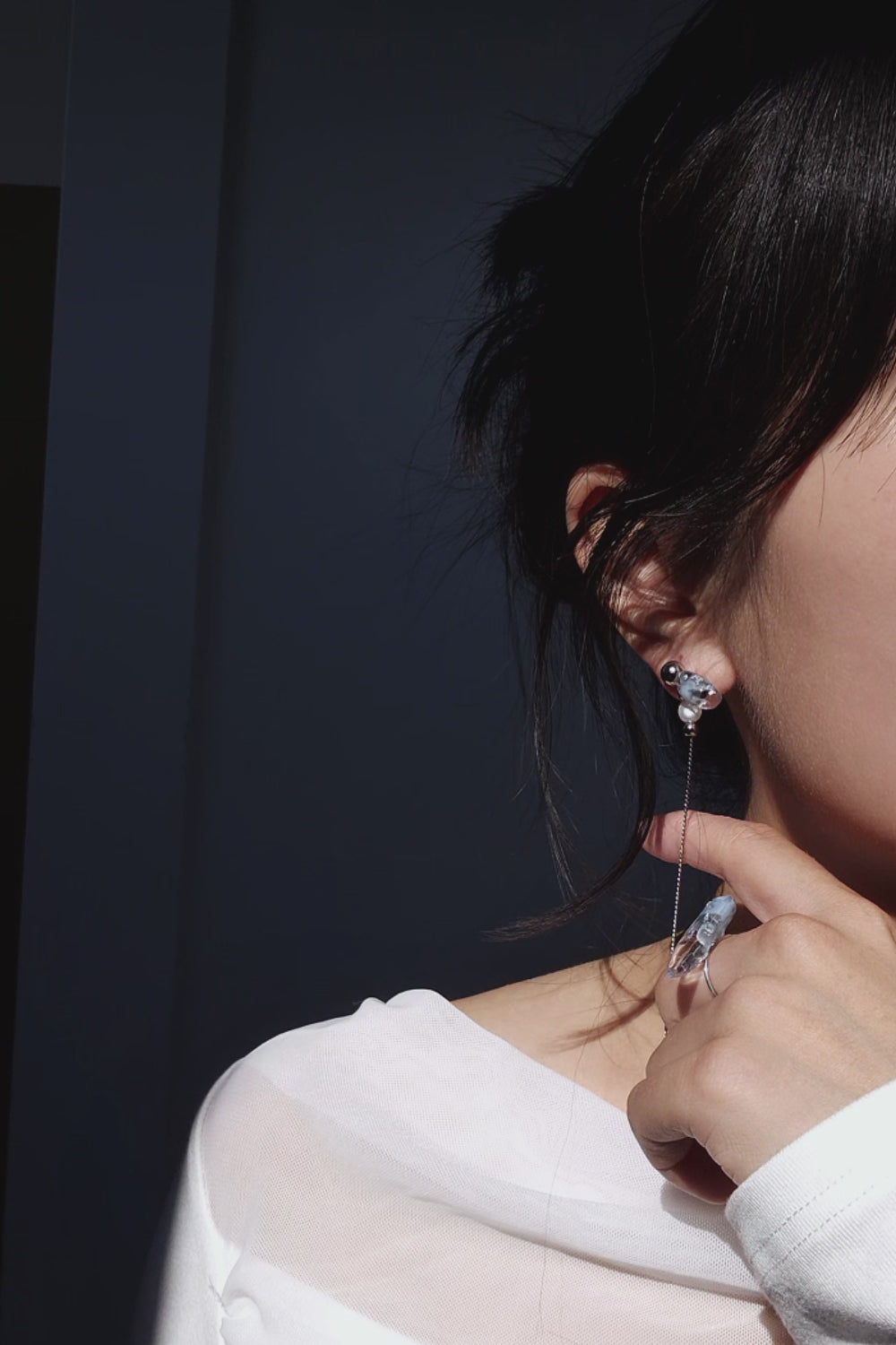 Video showcasing how to wear NAMI multiway drop earring showcasing detachable chain, freshwater pearl, and fluid silvery-blue glow.