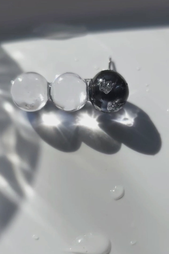 Close-up video of SORA vertical orb earrings showing gradient blue hues. Each orb is uniquely handcrafted.