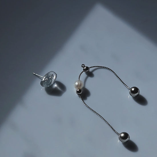 Video of NAMI multiway drop earring with adjustable chain and pearl, silvery-blue wave-inspired design.