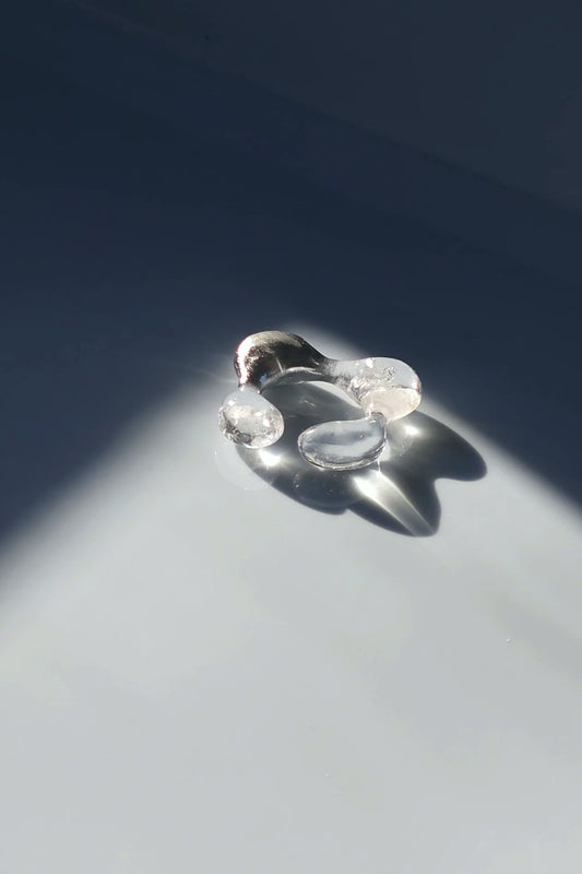REI square ring worn on finger, minimal yet bold with its hand-molded square shape and shimmering contrast of silver and translucent textures.