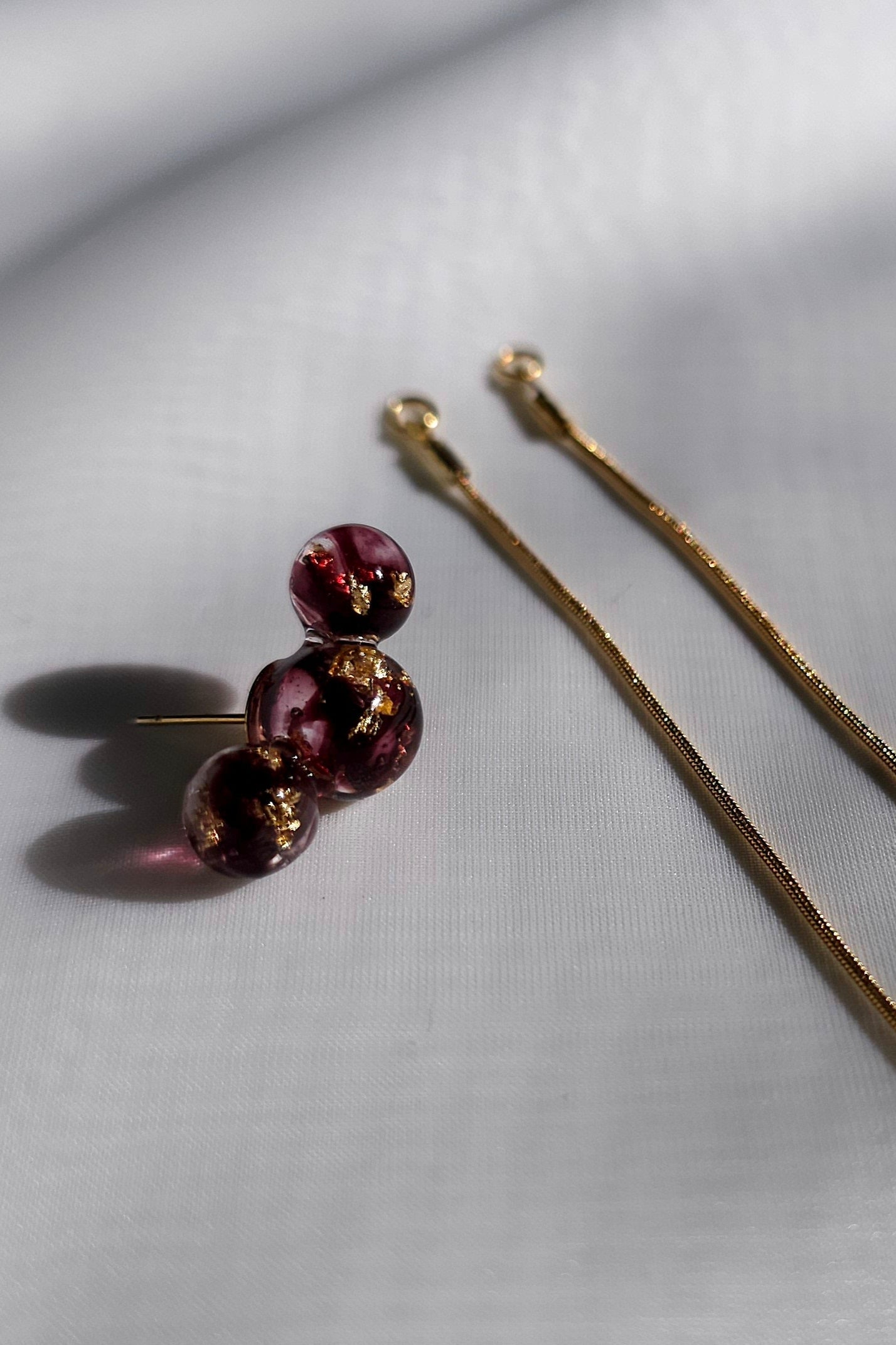 SAKURAMBO multiway chain ear cuff in rich dark cherry red with two detachable chains, flat lay on neutral background