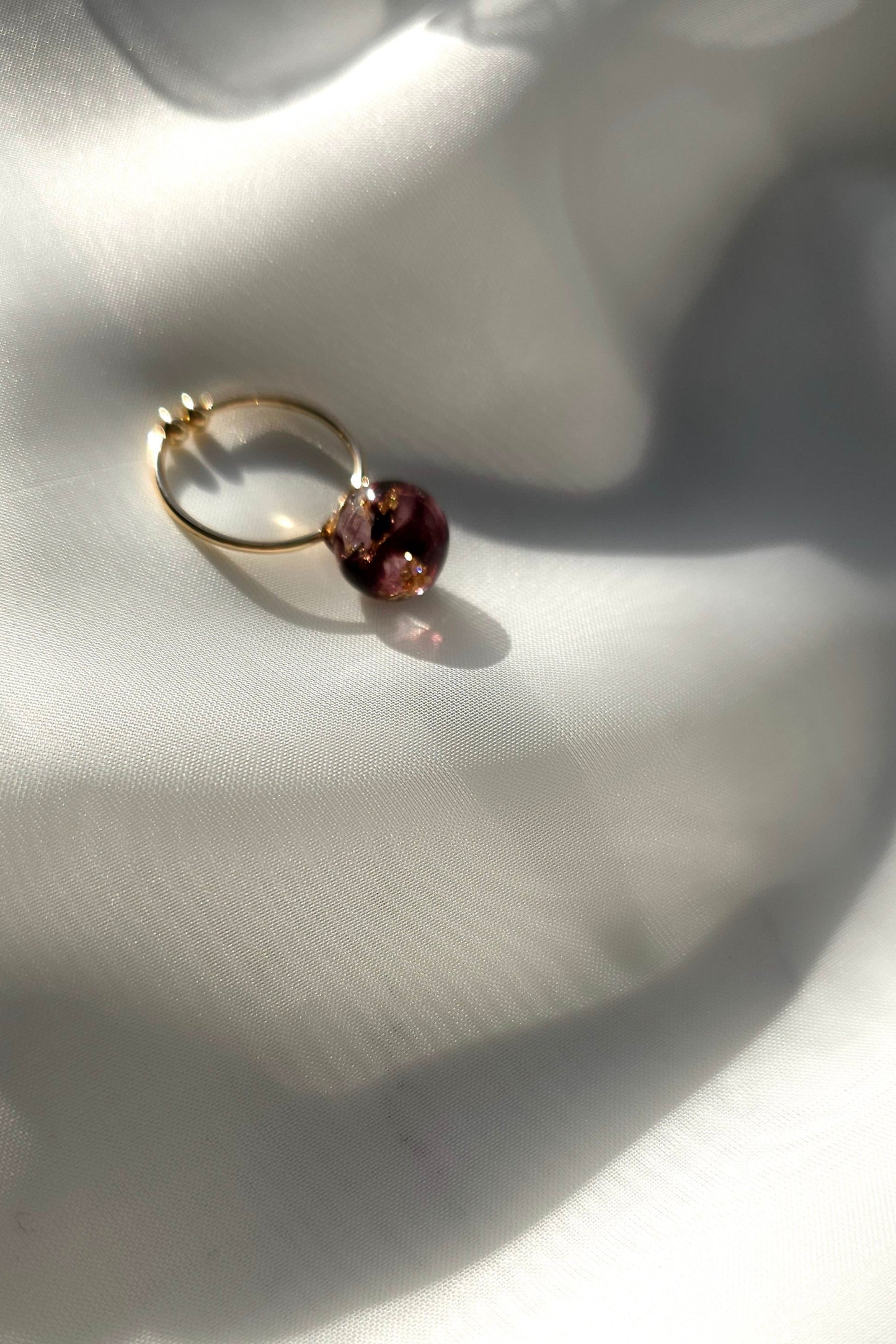 10mm orb ring in dark cherry, SAKURAMBO ring on a flat surface.