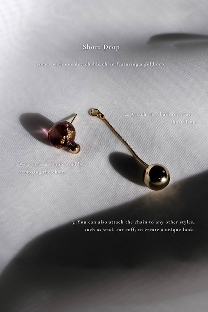 Orb drop in dark cherry with a detachable gold orb, SAKURAMBO short drop, on a flat surface.