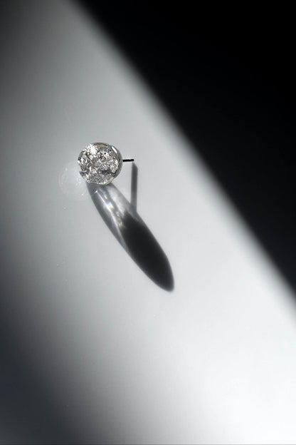 SUIKO stud earring inspired by shimmering water reflections, minimalist and captivating in soft silver and luminous clear tones.