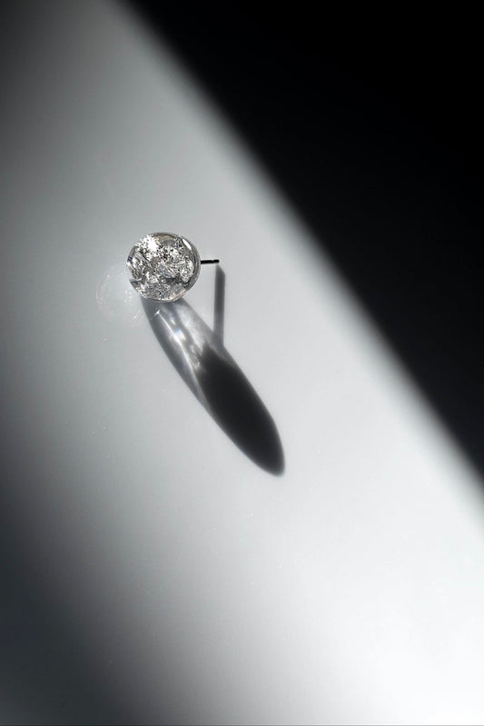 SUIKO stud earring inspired by shimmering water reflections, minimalist and captivating in soft silver and luminous clear tones.