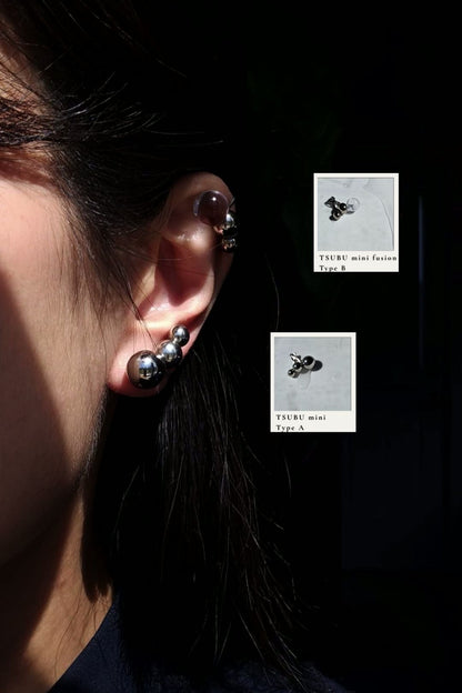 Person wearing TSUBU mini fusion Type B on helix with TSUBU mini silver Type A on the earlobe