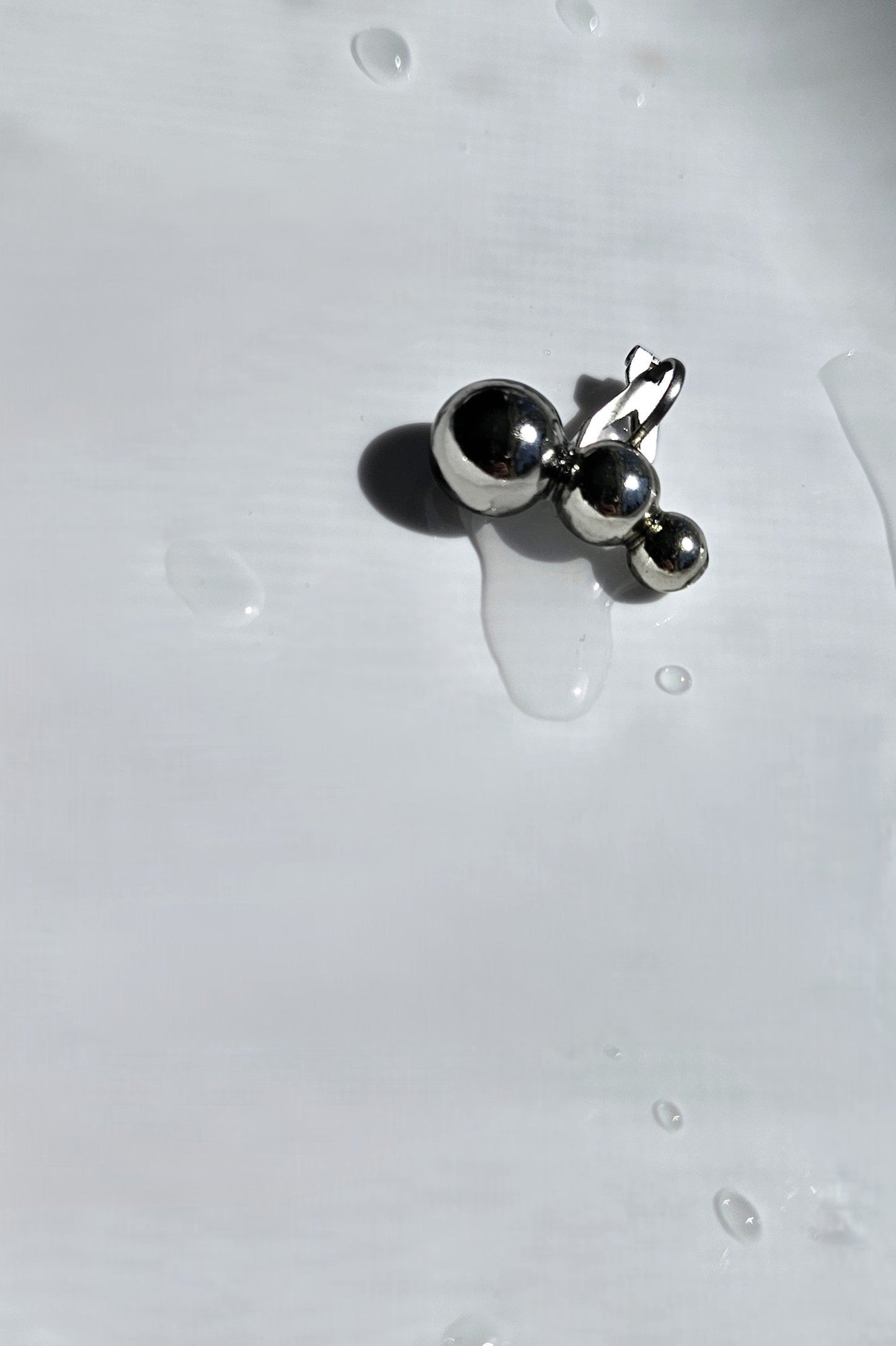 TSUBU mini silber climber features 3 different sizes of orbs. It fits the curve of our ear. No piercing holes required.