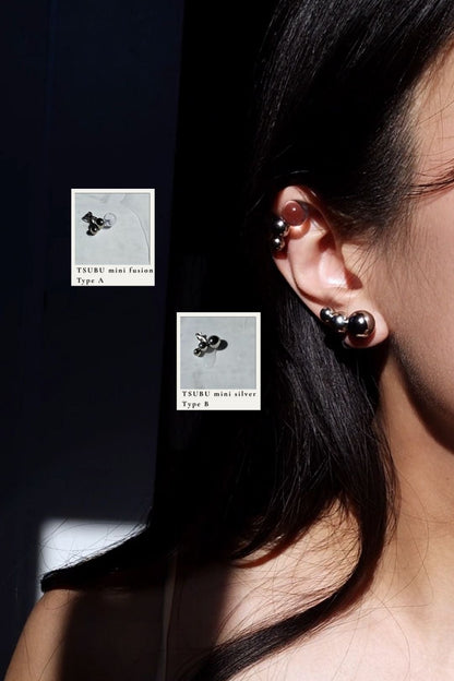 Close-up of a person wearing TSUBU mini silver orb ear cuff Type B on the earlove and TSUBU mini fusion Type A on the helix